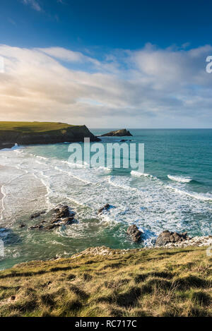 Late afternoon sunlight over Porth Joke Beach Polly Joke and the small rocky island called The Chick off Kelsey Head on the North Cornwall coast in En Stock Photo