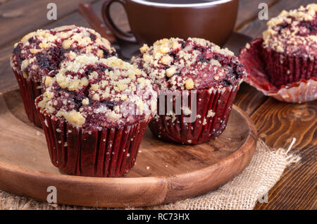 Closeup of a red velvet chocolate chip cupcakes on a wooden plate Stock Photo