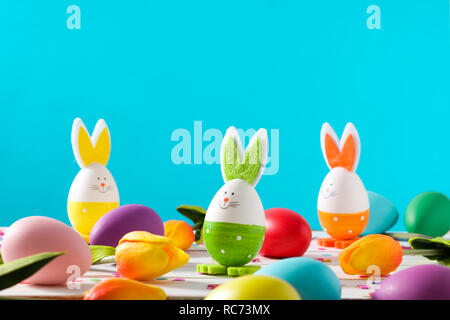 Easter holidays concept with easter eggs and rabbits on blue background Stock Photo
