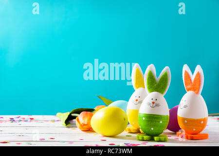 Easter holidays concept with easter eggs and rabbits on blue background Stock Photo