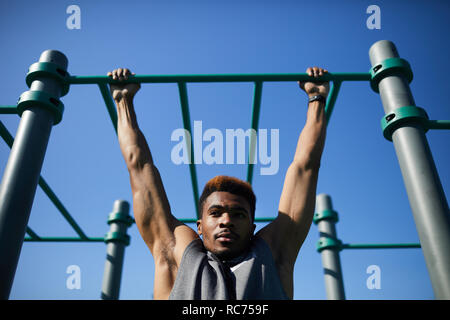 Black man doing pull-up on bar Stock Photo
