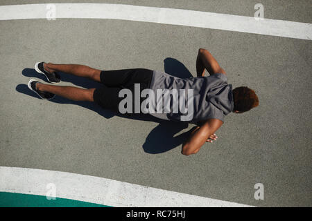 Strong black man doing push-ups on ground Stock Photo