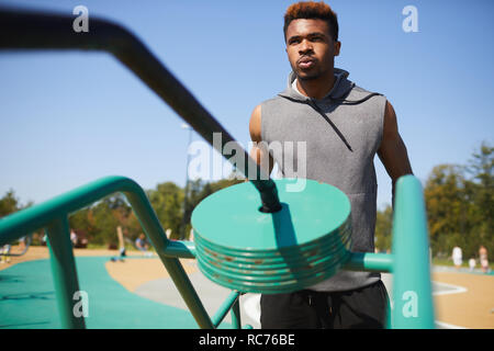 Black man breathing out while training with workout equipment Stock Photo