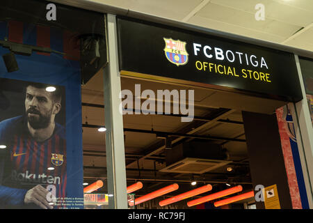 entrance to the fc botiga store of the fc barcelona footbal team with a poster by Gerard Pique in the shop window. Logo fc barcelona, Spain Stock Photo