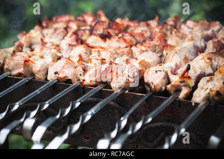 Pork shashlik preparing on coals, a dish of skewered and grilled cubes of meat Stock Photo