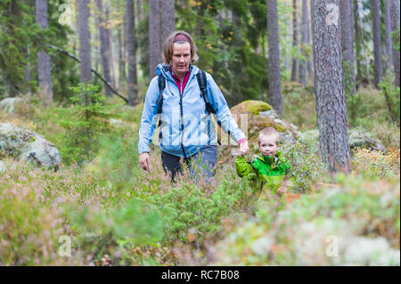 Mother walking with son through forest Stock Photo