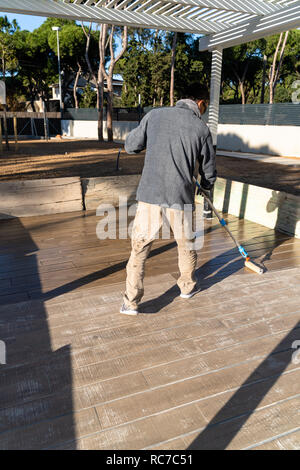 Construction worker painting the floor with epoxy based paint, hard durability , Barcelona, ​​Spain Stock Photo