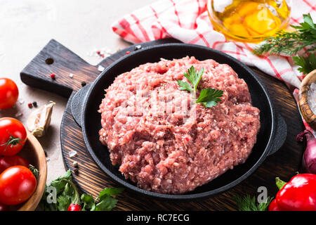 Minced meat in black iron plate with ingredients for cooking. Stock Photo