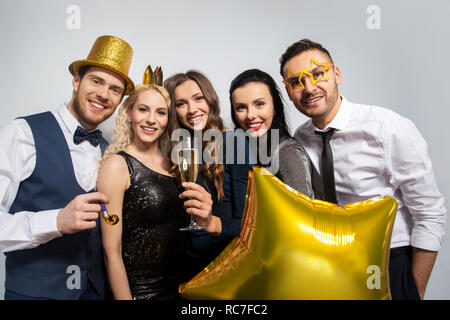 happy friends with golden party props posing Stock Photo