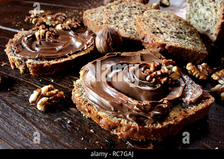 Walnut bread with chocolate spread on wooden background Stock Photo