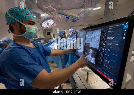 Doctors performing spine surgery using neuronavigation computer-assisted technology system Stock Photo