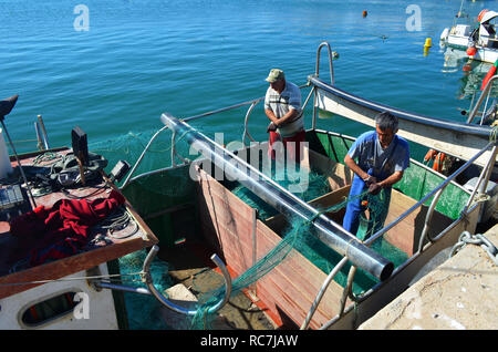Fishermen working onboard an artisanal gillnetter in Lagos harbour, Algarve, Portugal Stock Photo