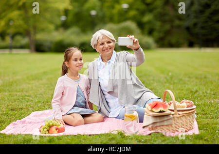 grandmother and granddaughter take selfie at park Stock Photo