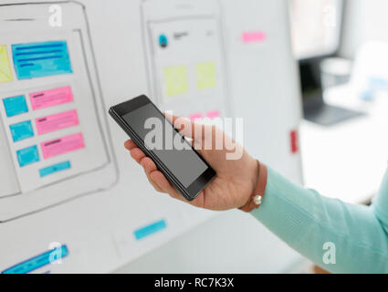 ui designer or developer hand holding smartphone Stock Photo