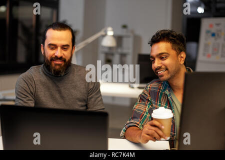 creative team drinking coffee at night office Stock Photo