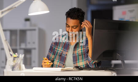creative man with notebook working at night office Stock Photo