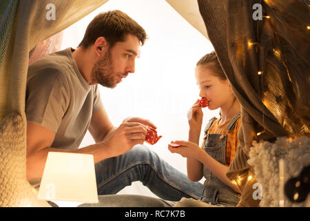 family playing tea party in kids tent at home Stock Photo