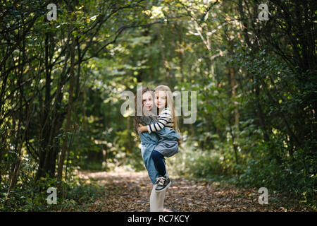 Sisters hugging in forest Stock Photo