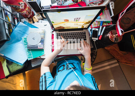 Boy playing games on laptop Stock Photo