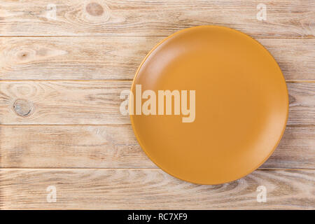 Directy above Empty yellow matte dish for dinner on dark wooden ...