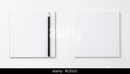 Design concept - Top view of pure white notebook, white page and pencil isolated on background for mockup Stock Photo