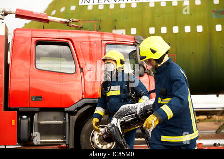 Firemen training, firemen in breathing apparatus carrying equipment Stock Photo