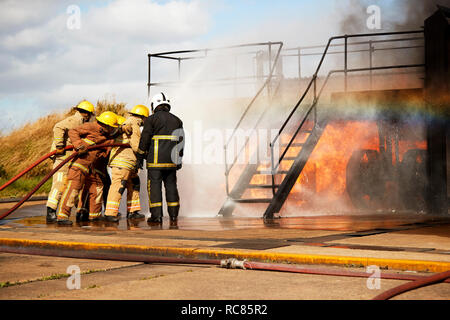 Firemen training, firemen spraying water at training facility stairway Stock Photo