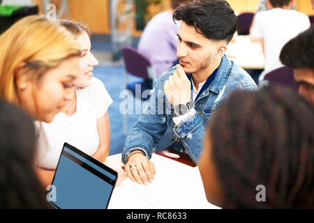 Female and male higher education students studying in college classroom, over shoulder view Stock Photo