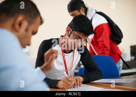 Lecturer talking to college students in classroom Stock Photo