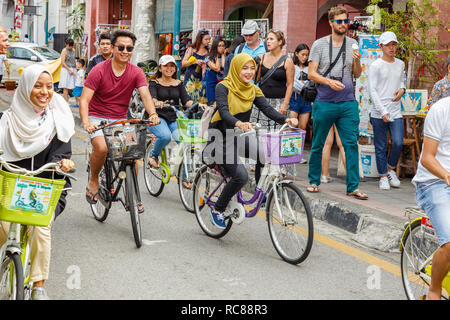 Happy people ride rented bicycles on a city street. Stock Photo