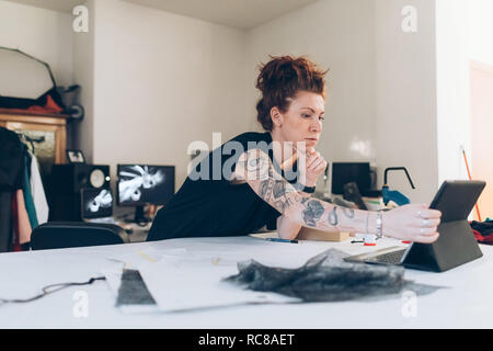 Fashion designer researching using digital tablet Stock Photo