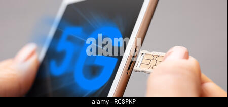 sim card and mobile phone in female hands Stock Photo