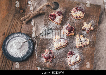 Shortbread biscuits with cherry filling on the wooden board Stock Photo