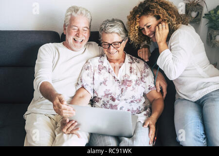 family cacuasian people in indoor technology leisure activity at home using laptop and having fun eith internet or video chat with friends or parents  Stock Photo