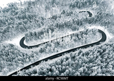 Curved winding road in the forest in winter time Stock Photo