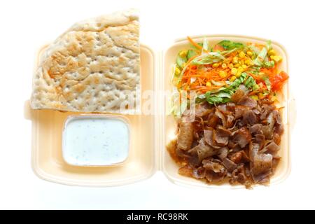 Fast food, doner kebab plate, with doner meat, salad, garlic-yogurt sauce and pita bread in plastic takeaway packaging Stock Photo