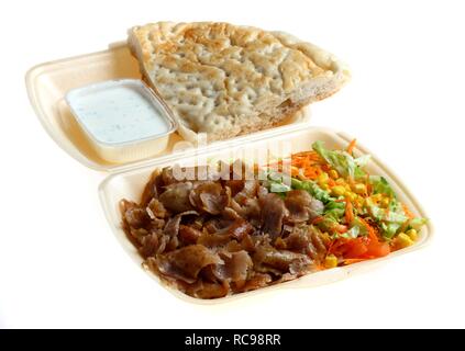 Fast food, doner kebab plate, with doner meat, salad, garlic-yogurt sauce and pita bread in plastic takeaway packaging Stock Photo