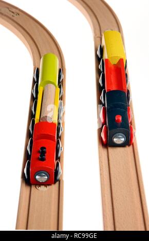 Toy wooden trains, two trains on the tracks, symbolic image of a race, competition Stock Photo