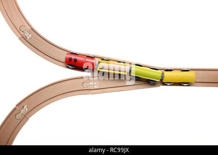 Toy wooden train at a switch, symbolic image for deciding the direction Stock Photo