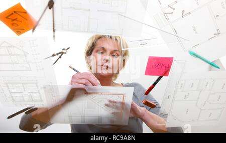 Architect working on a construction drawing on a table Stock Photo