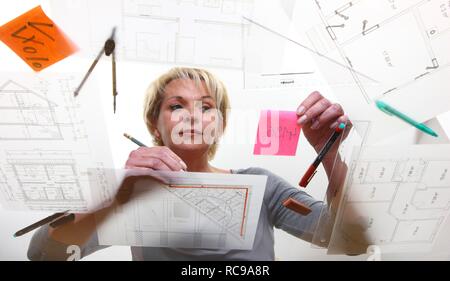 Architect working on a construction drawing on a table Stock Photo