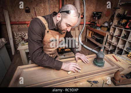 man sanding wood in his workshop Stock Photo