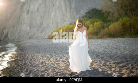 Bride in wedding dress on beach at sunset, Scarborough Bluffs, Toronto, Canada Stock Photo