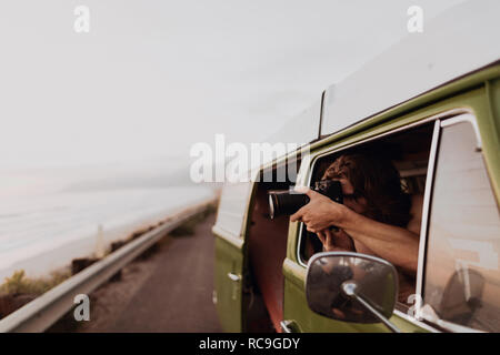 Man on van road trip photographing coast, Ventura, California, US Stock Photo