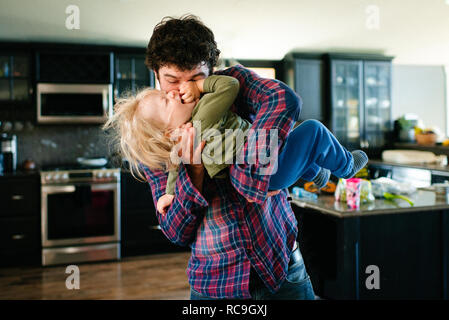 Father and son playing in kitchen Stock Photo