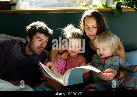 Parents reading to children in bed Stock Photo