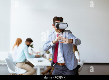 Businessman making team training exercise during team building seminar using VR glasses in office Stock Photo