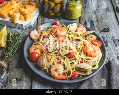 Cooked pasta with clams, shrimps tomato on a plate , spaghetti Stock Photo