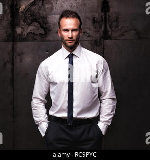 handsome man wearing white shirt on a grunge background. Stock Photo