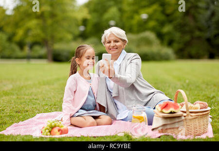 grandmother and granddaughter take selfie at park Stock Photo